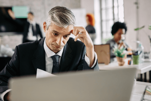 A capable professional man in his 40s looking thoughtful in a modern office, representing memory loss in your 40s and the search for cognitive clarity.