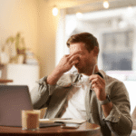A professional man in her 50s staring blankly at a screen, illustrating why people feel mentally exhausted by 2pm due to cognitive resource depletion.