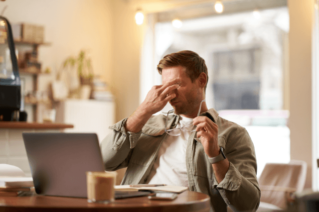 A professional man in her 50s staring blankly at a screen, illustrating why people feel mentally exhausted by 2pm due to cognitive resource depletion.