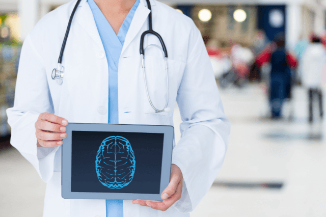 A close-up of a doctor in a white coat and stethoscope holding a tablet displaying a detailed blue cerebral brain scan. The doctor’s hands present the tablet clearly, suggesting authority, diagnosis, and cognitive health solutions in a clinical setting. Minimalist professional background.
