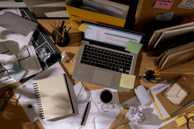 Overhead flat-lay of a cluttered modern desk with coffee, phone notifications and energy drinks, symbolizing the daily habits that quietly drain mental clarity and cause brain fog.
